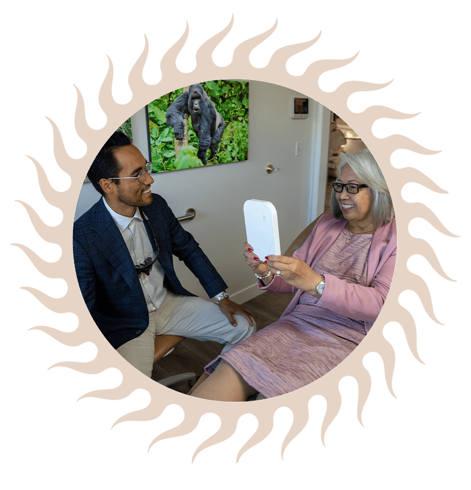 Patient looking into mirror smiling after dental implants procedure